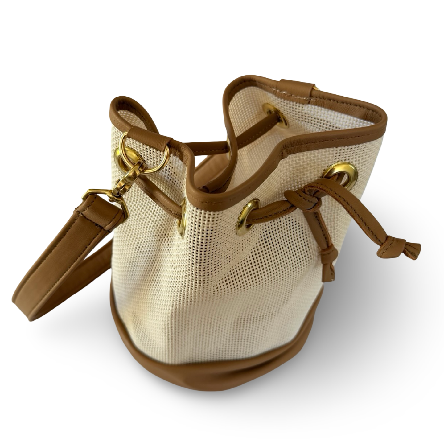 Beige bucket bag with brown leather accents on a white background