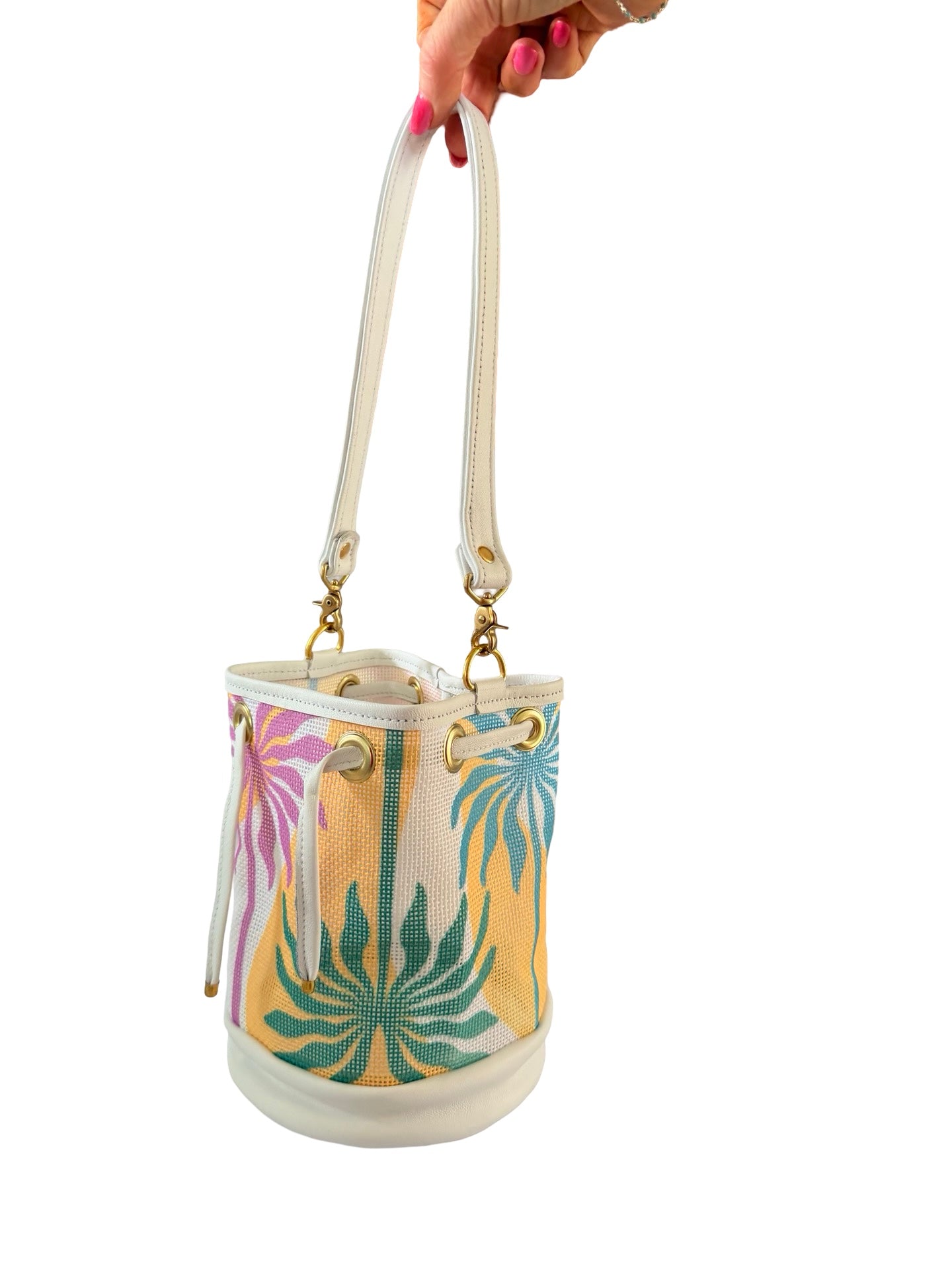 Handbag with floral pattern held by a hand on a white background